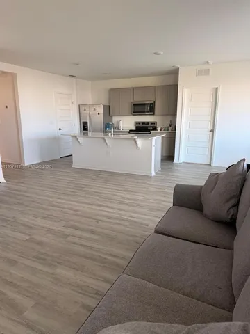 a living room with furniture and kitchen view