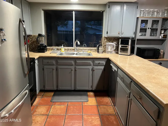 a kitchen with a sink a counter top space and stainless steel appliances