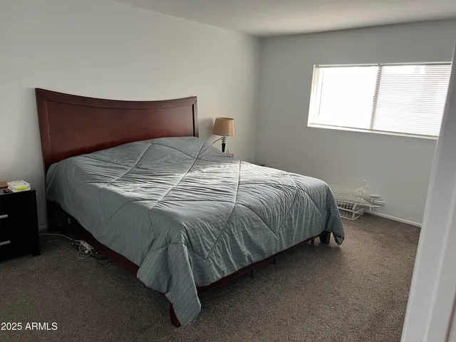 a bed sitting in a bedroom next to a window