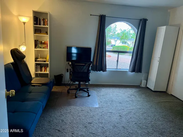 a view of a workspace with furniture and a window