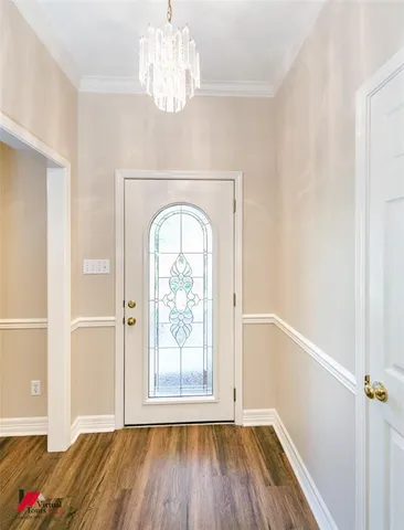 a view of empty room with wooden floor and window