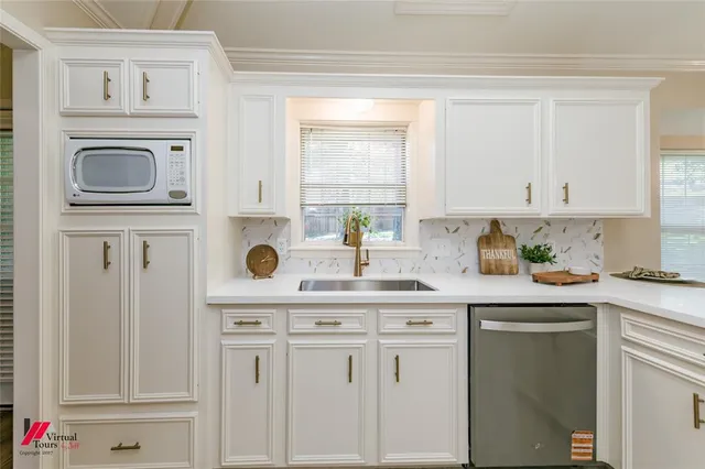 a kitchen with white cabinets and white appliances