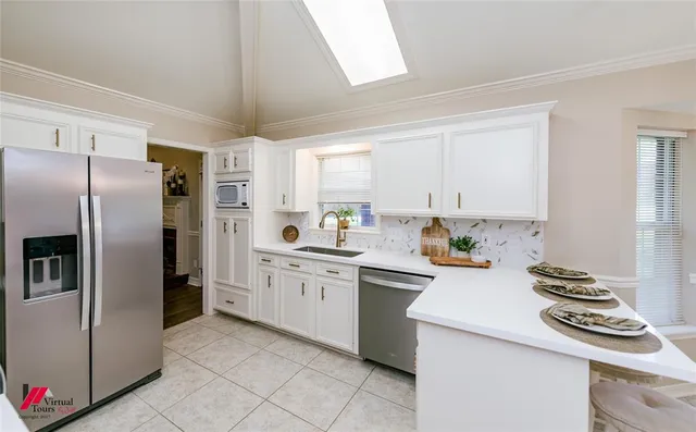 a kitchen with granite countertop a sink stainless steel appliances and cabinets