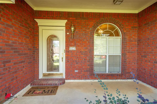an empty room with wooden floor fireplace and windows