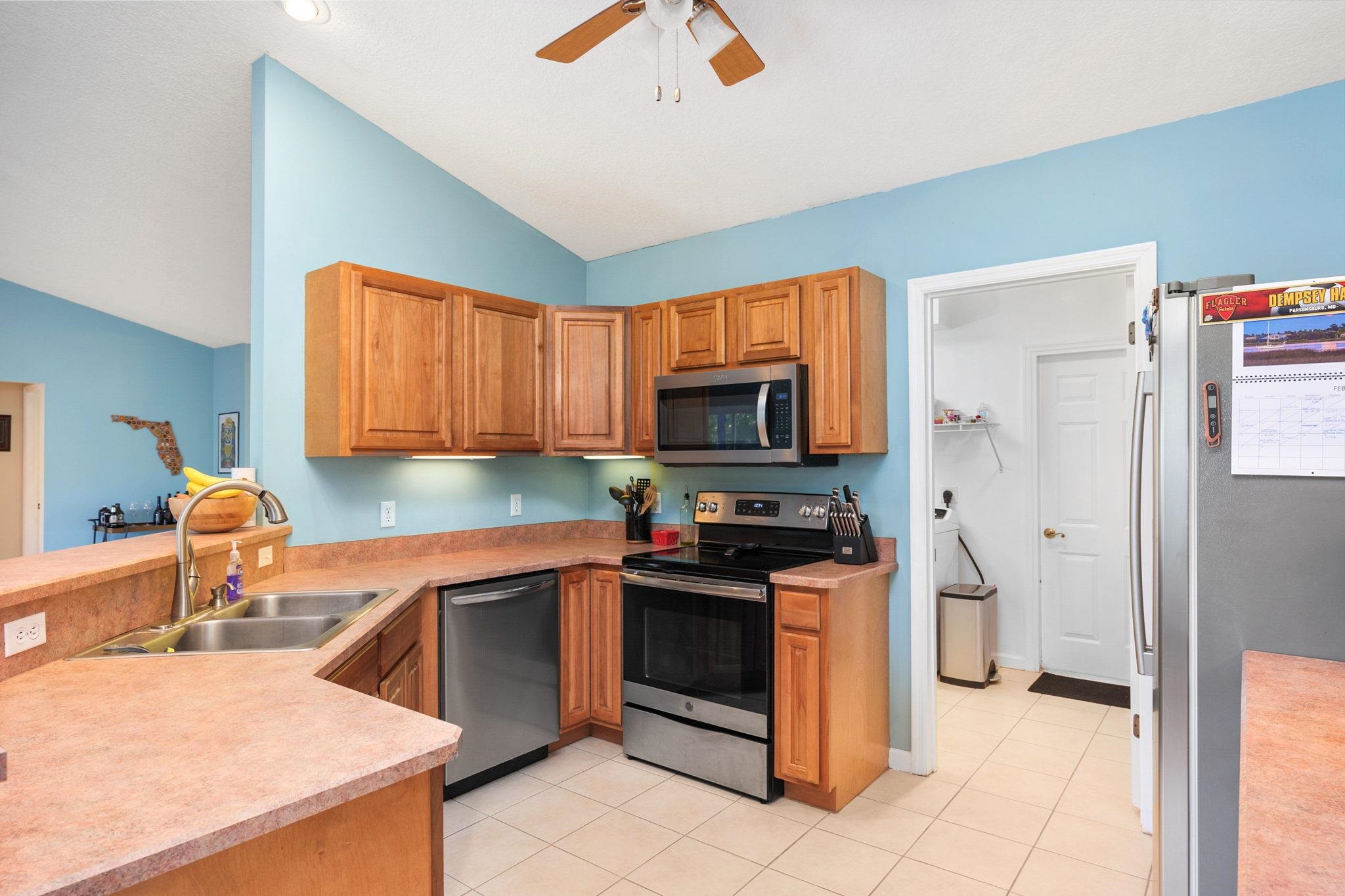 235 Shamrock Road St. Augustine, FL 32086 - Photo 13 of 28 a kitchen with stainless steel appliances granite countertop a stove a sink and a refrigerator