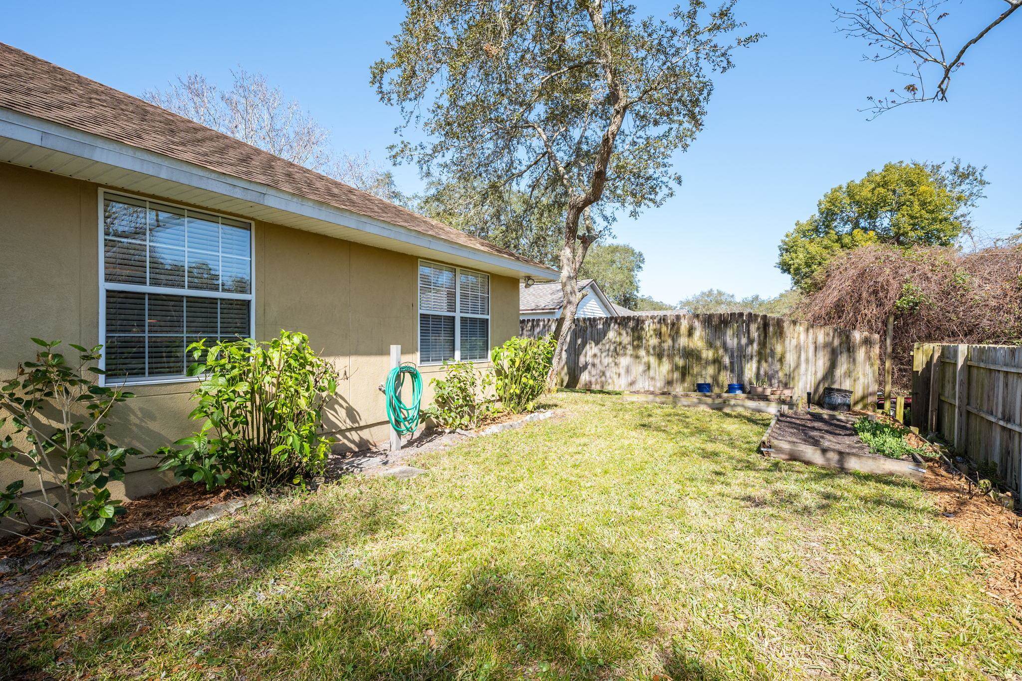 235 Shamrock Road St. Augustine, FL 32086 - Photo 27 of 28 a view of a house with small yard plants and large tree