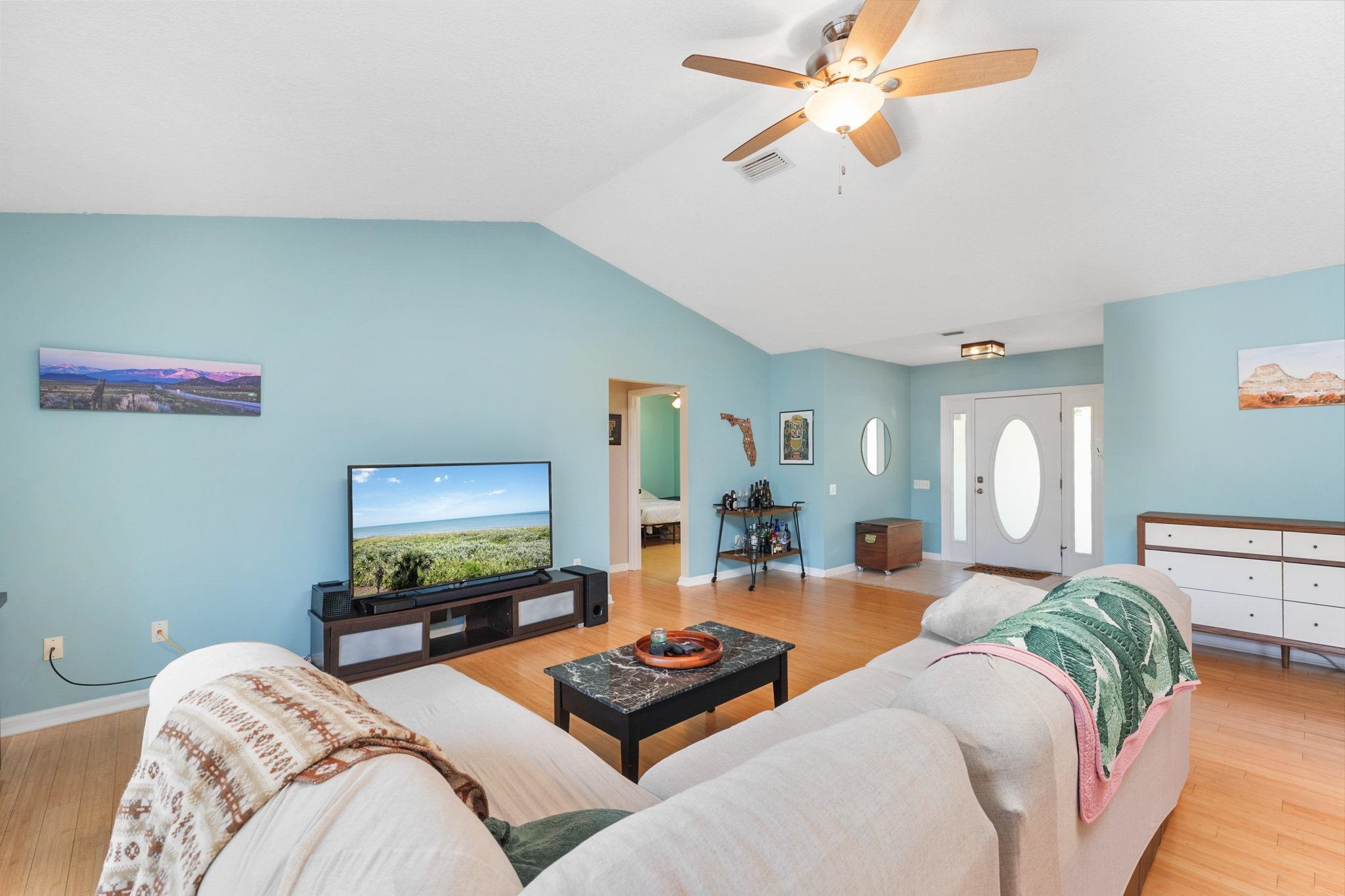 235 Shamrock Road St. Augustine, FL 32086 - Photo 9 of 28 a bedroom with furniture a flat screen tv and a chandelier
