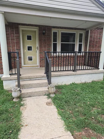 a view of a house with a small yard and wooden floor and fence