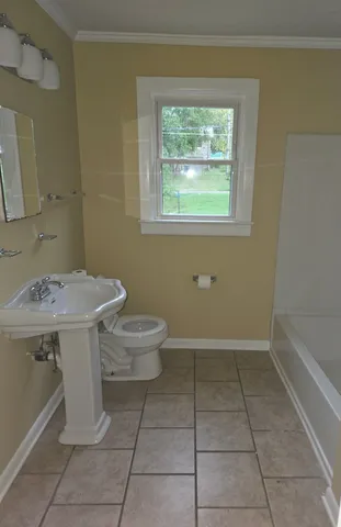 a bathroom with a sink toilet and window