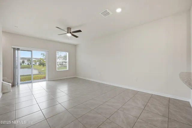 an empty room with windows and fan