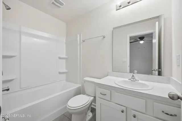 a bathroom with a granite countertop sink a toilet and shower