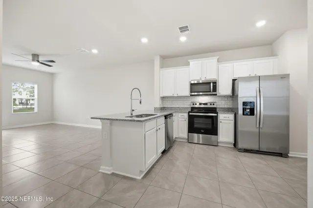 a kitchen with stainless steel appliances a refrigerator sink and stove