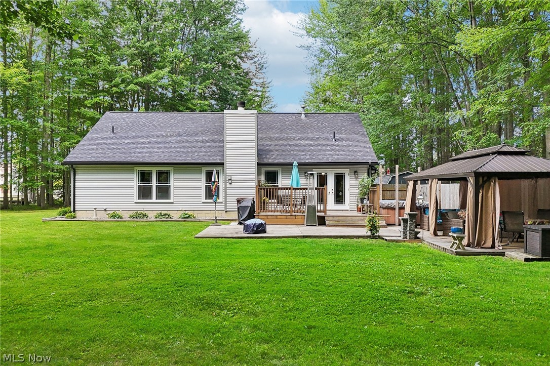 3213 Bates Road Madison, OH 44057 - Photo 45 of 45 Expansive green lawn bordering a light-sided residence with a dark shingle roof and a prominent chimney