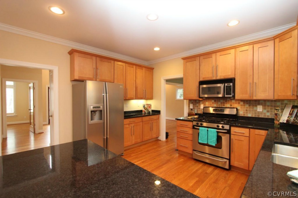 10224 Sioux Road Richmond, VA 23235 - Photo 8 of 24 a kitchen with stainless steel appliances granite countertop a stove a refrigerator a sink a oven with wooden cabinets and wooden floor
