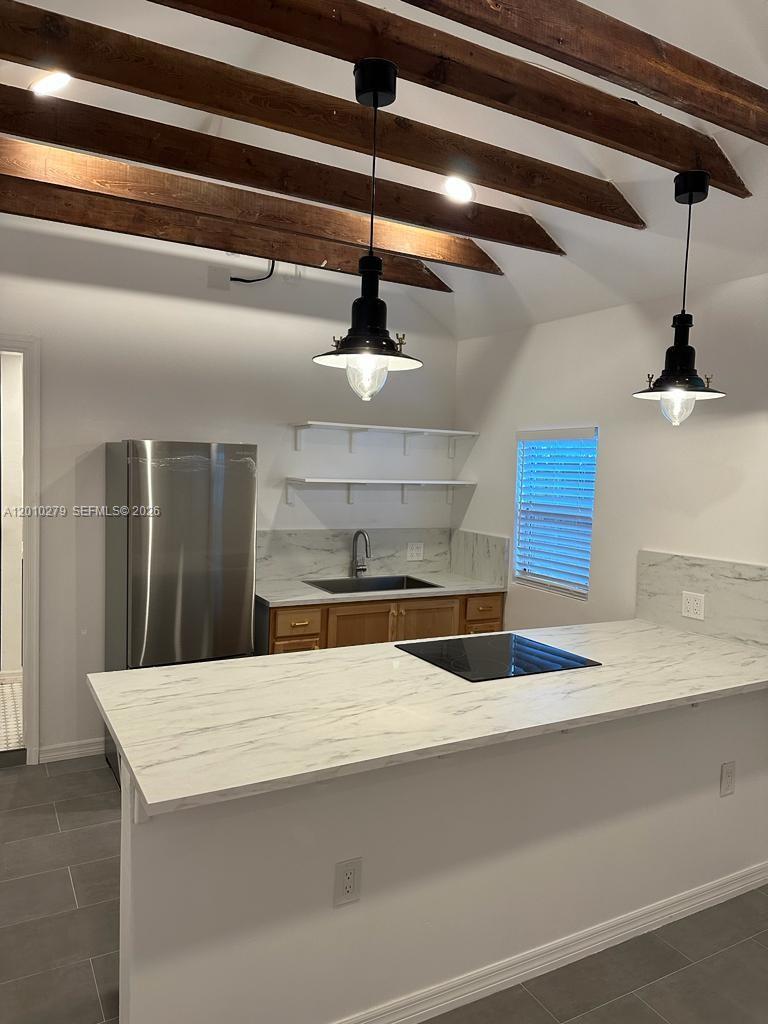 3113 Southwest 14th Street, Unit A Miami, FL 33145 - Photo 2 of 12 a kitchen with kitchen island a sink stainless steel appliances and cabinets