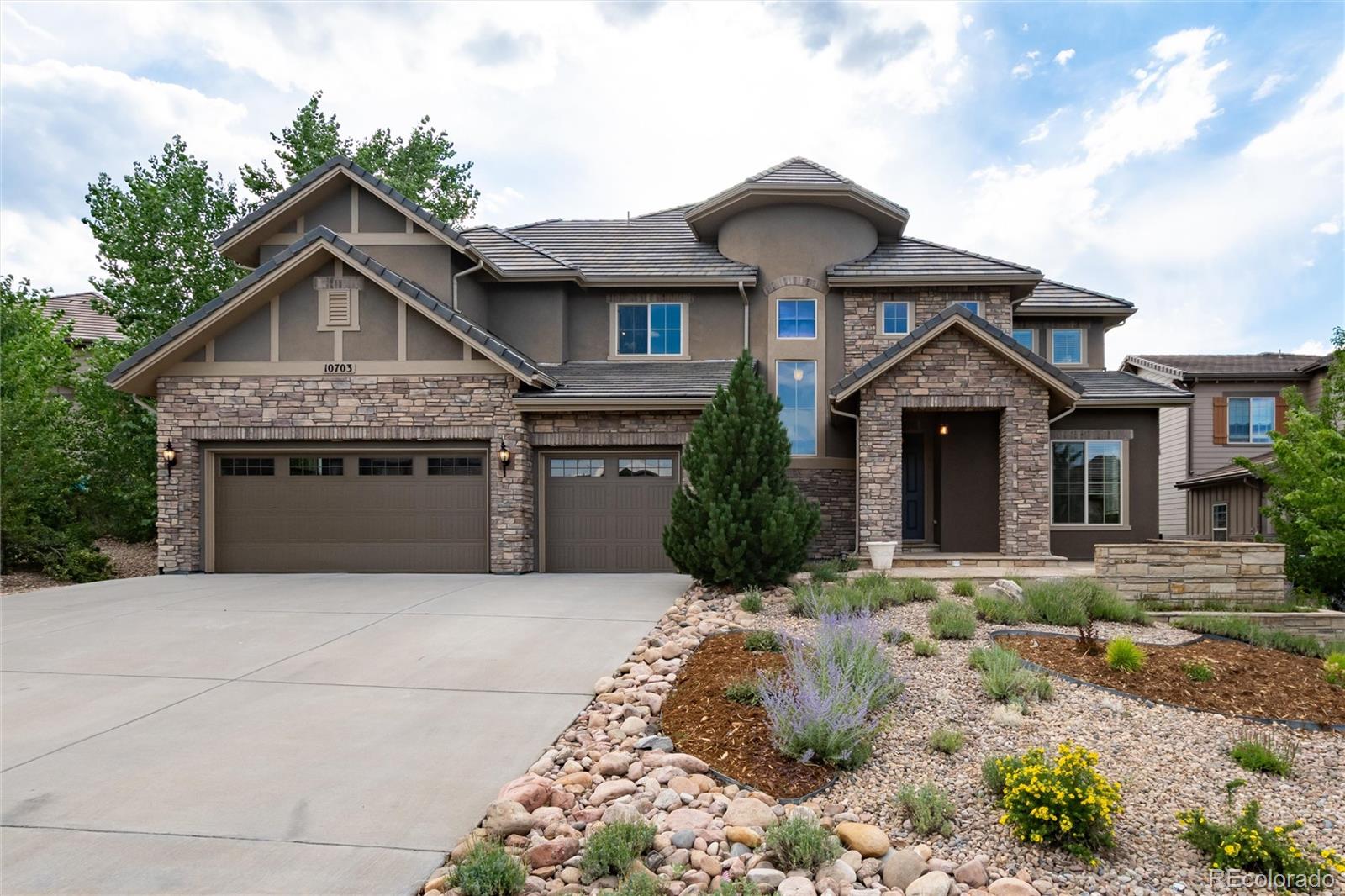 10703 Braesheather Court Highlands Ranch, CO 80126 - Photo 11 of 48 a front view of a house with a yard and garage