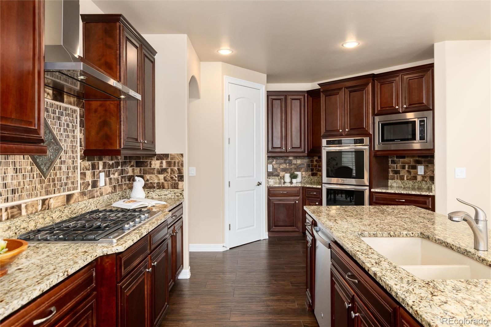 10703 Braesheather Court Highlands Ranch, CO 80126 - Photo 24 of 48 a kitchen with stainless steel appliances granite countertop a sink stove and refrigerator