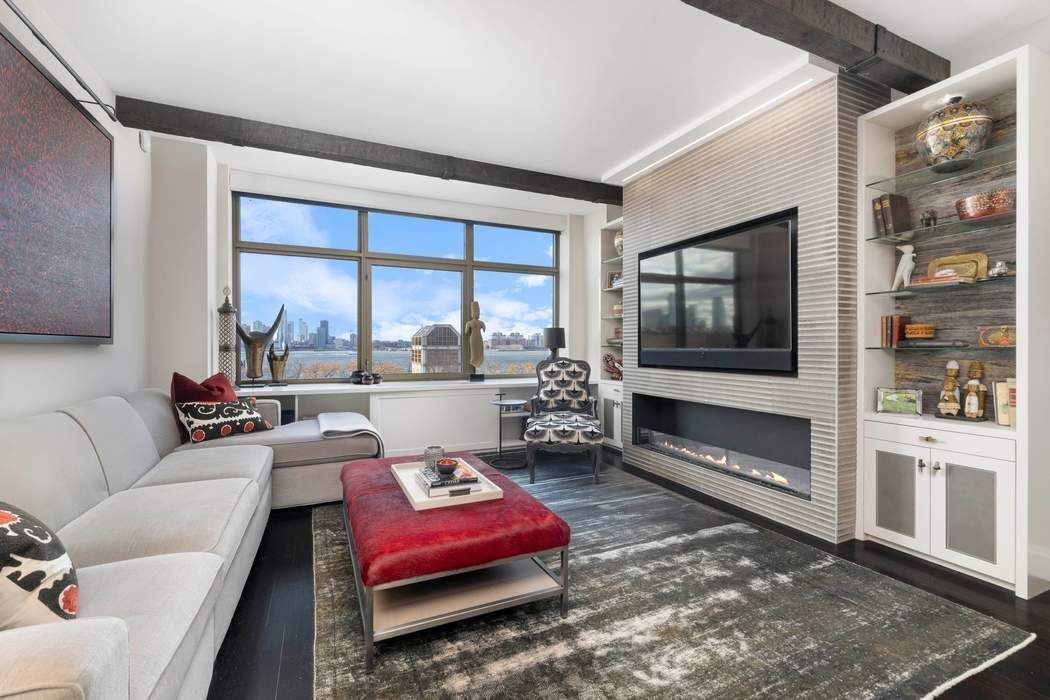 a living room with furniture a flat screen tv and a floor to ceiling window