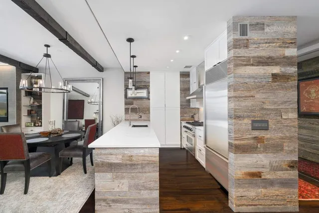 a kitchen with refrigerator and chairs