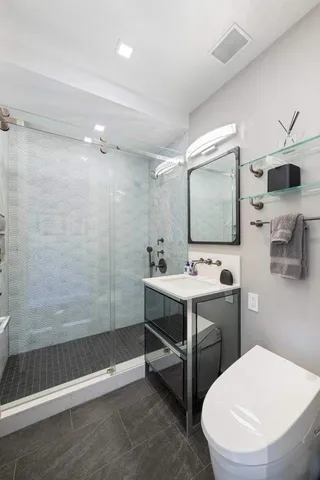 a bathroom with a sink a toilet and shower