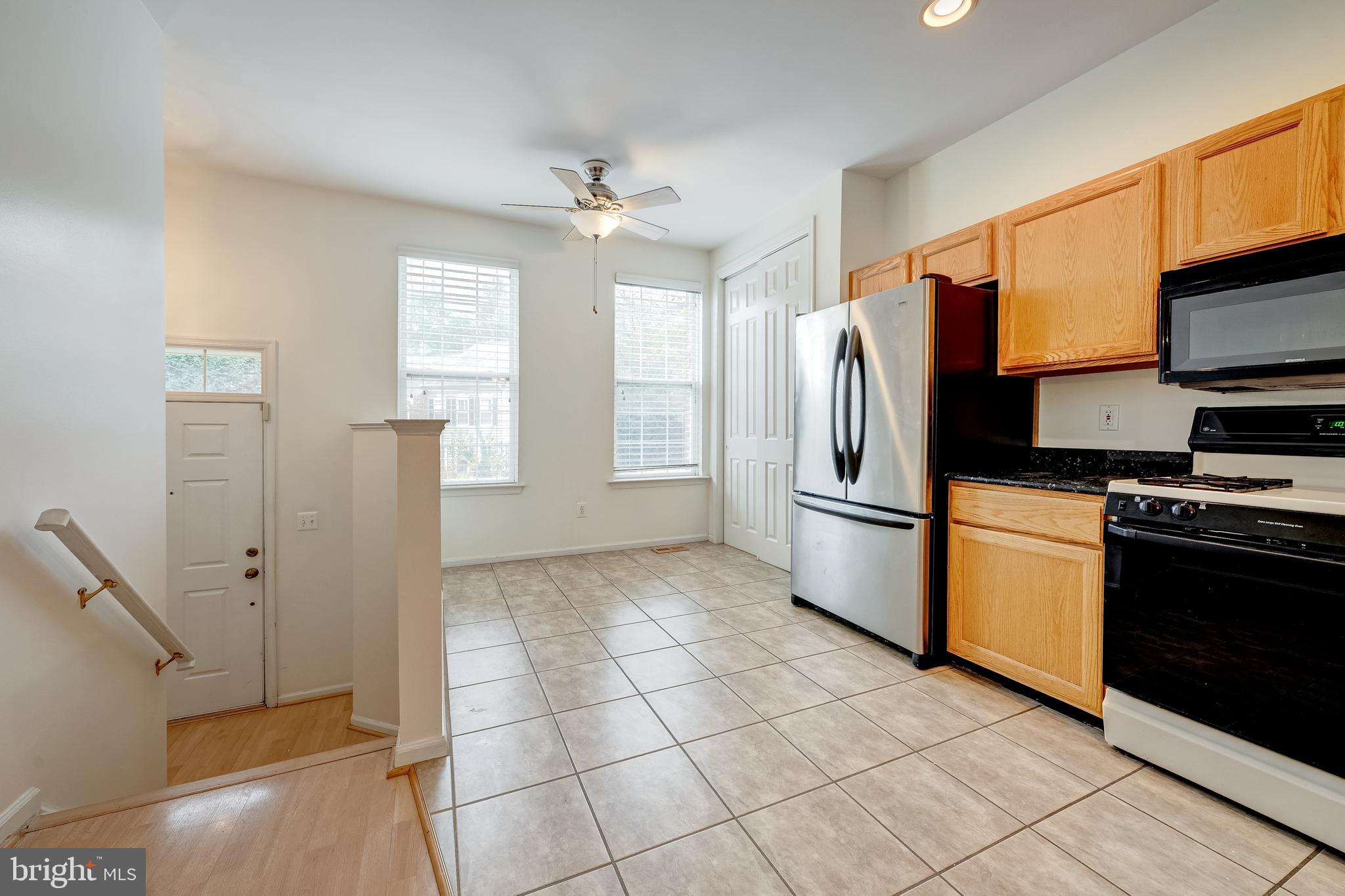 11444 Heritage Commons Way Reston, VA 20194 - Photo 11 of 35 a kitchen with stainless steel appliances granite countertop a refrigerator a stove and a sink