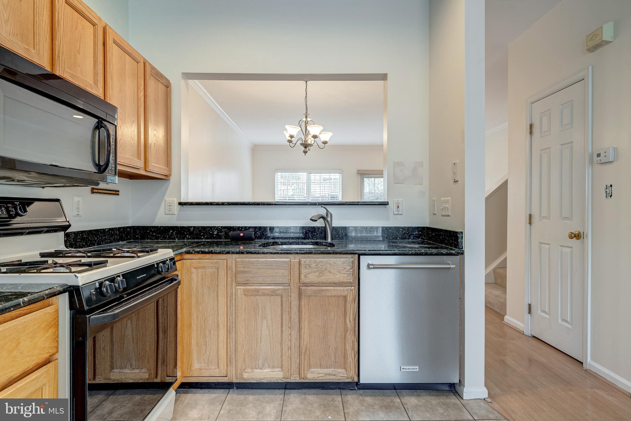 11444 Heritage Commons Way Reston, VA 20194 - Photo 12 of 35 a kitchen with stainless steel appliances granite countertop a stove a sink and a microwave