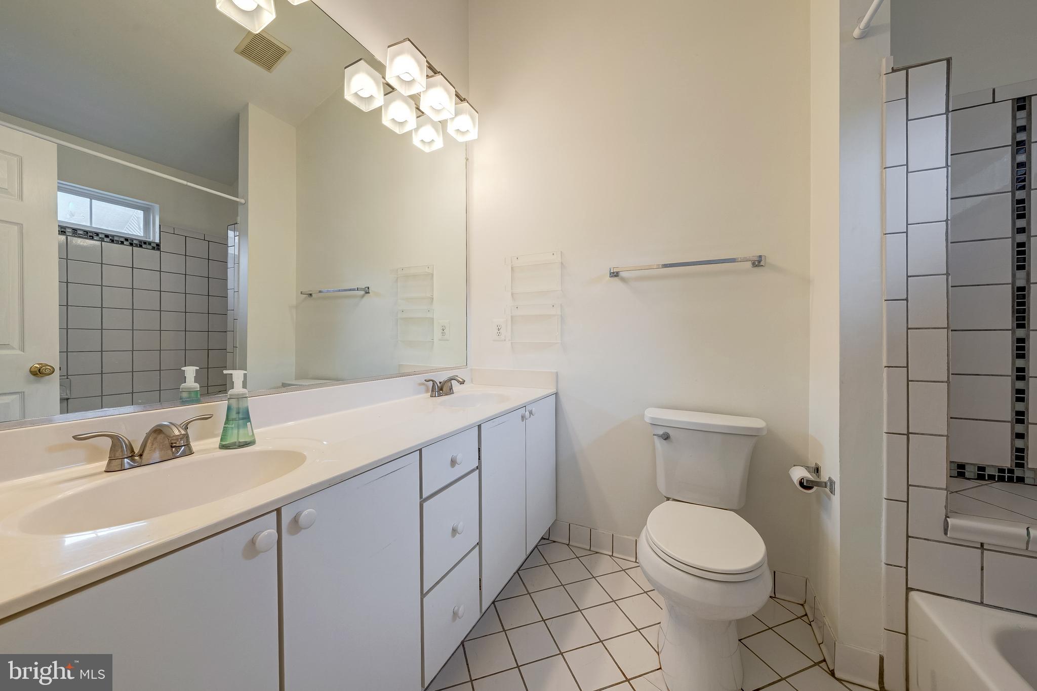 11444 Heritage Commons Way Reston, VA 20194 - Photo 18 of 35 a bathroom with a toilet a sink a mirror and vanity