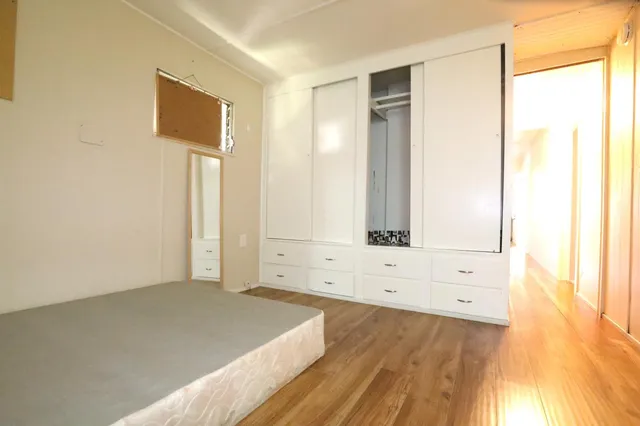 a view of a bedroom with wooden floor and cabinet