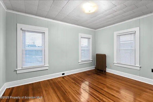 a view of a room with wooden floor and furniture
