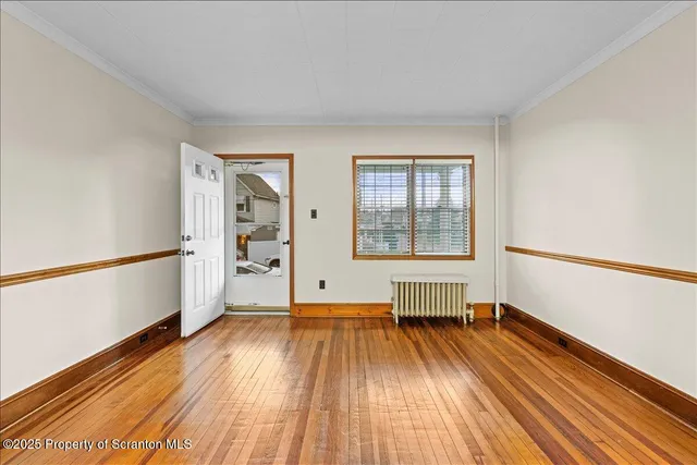 a view of empty room with wooden floor