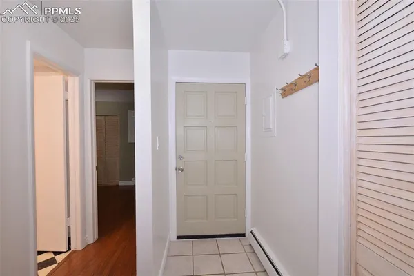 an empty room with wooden floor chandelier fan and windows