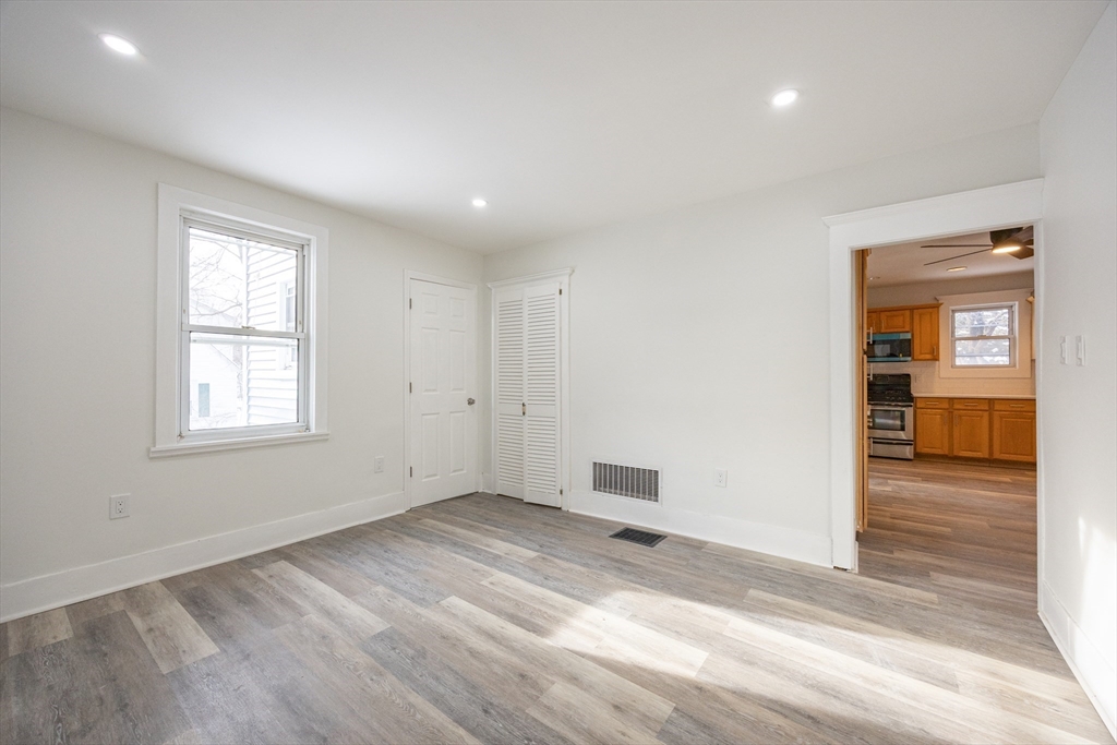 153 West Street Randolph, MA 02368 - Photo 12 of 33 an empty room with wooden floor and windows