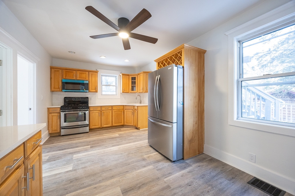 153 West Street Randolph, MA 02368 - Photo 3 of 33 a kitchen with granite countertop a refrigerator oven a sink and wooden floors