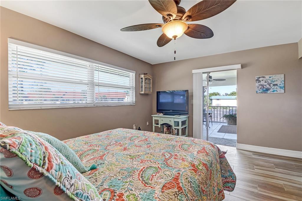 600 Valley Stream Drive, Unit E8 Naples, FL 34113 - Photo 12 of 21 a bedroom with a bed dresser and a flat tv screen