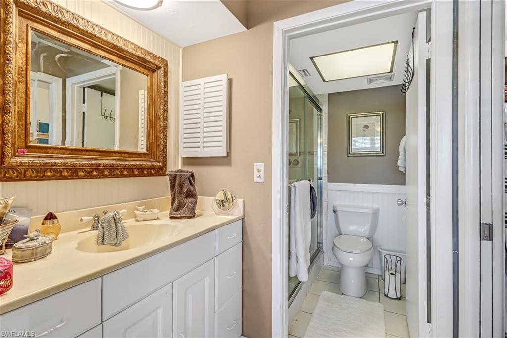 600 Valley Stream Drive, Unit E8 Naples, FL 34113 - Photo 15 of 21 a bathroom with a granite countertop sink mirror and toilet