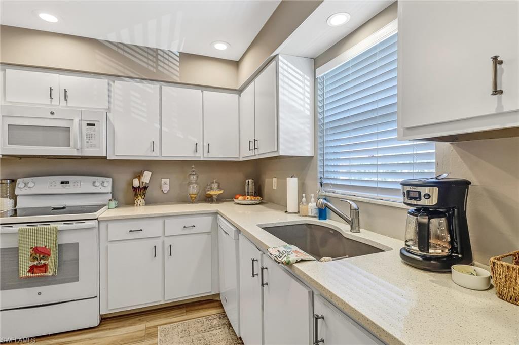 600 Valley Stream Drive, Unit E8 Naples, FL 34113 - Photo 3 of 21 a kitchen with cabinets appliances a sink and a counter space