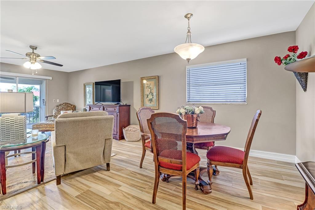600 Valley Stream Drive, Unit E8 Naples, FL 34113 - Photo 10 of 21 a view of a dining room with furniture and wooden floor