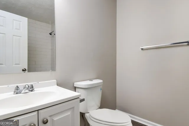 a bathroom with a sink a toilet and a mirror