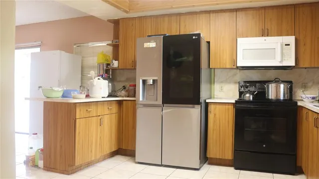 a kitchen with stainless steel appliances granite countertop a refrigerator and a stove