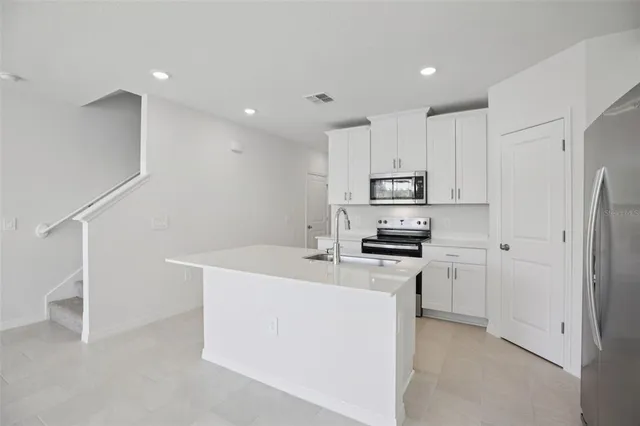 a kitchen with white cabinets and stainless steel appliances