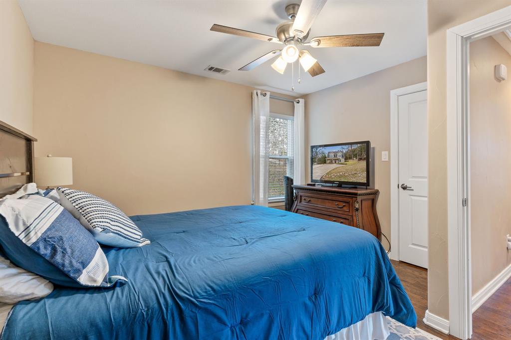 150 Spanish Trail Pottsboro, TX 75076 - Photo 18 of 36 a bedroom with a bed and a chandelier