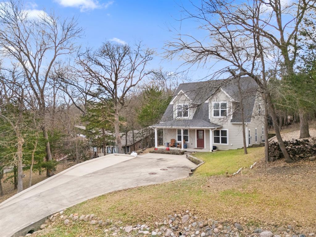 150 Spanish Trail Pottsboro, TX 75076 - Photo 31 of 36 a view of a white house with a large tree next to a yard with large trees