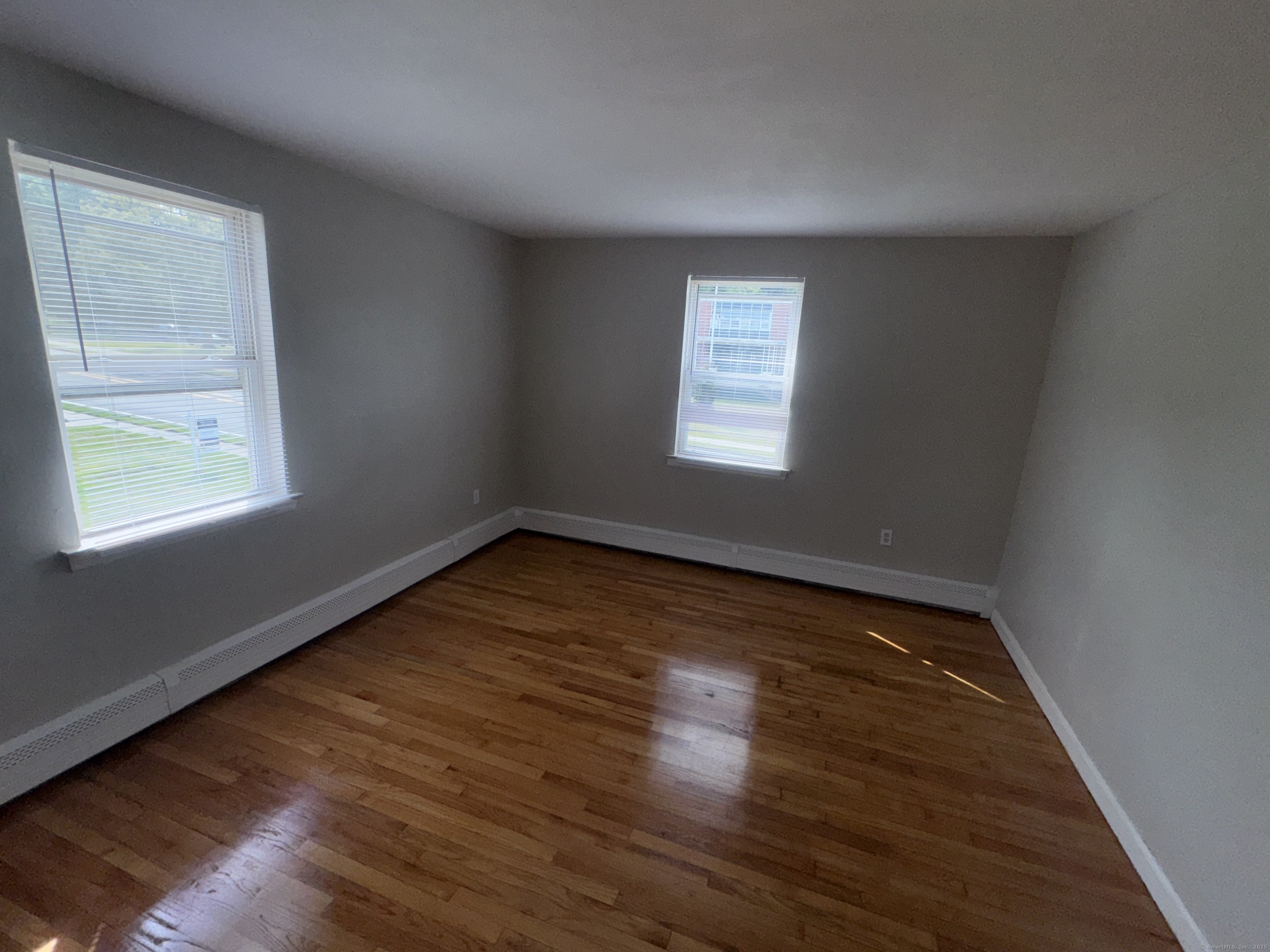 768 New Britain Avenue, Unit 2 Hartford, CT 06106 - Photo 10 of 17 a view of an empty room with wooden floor and a window