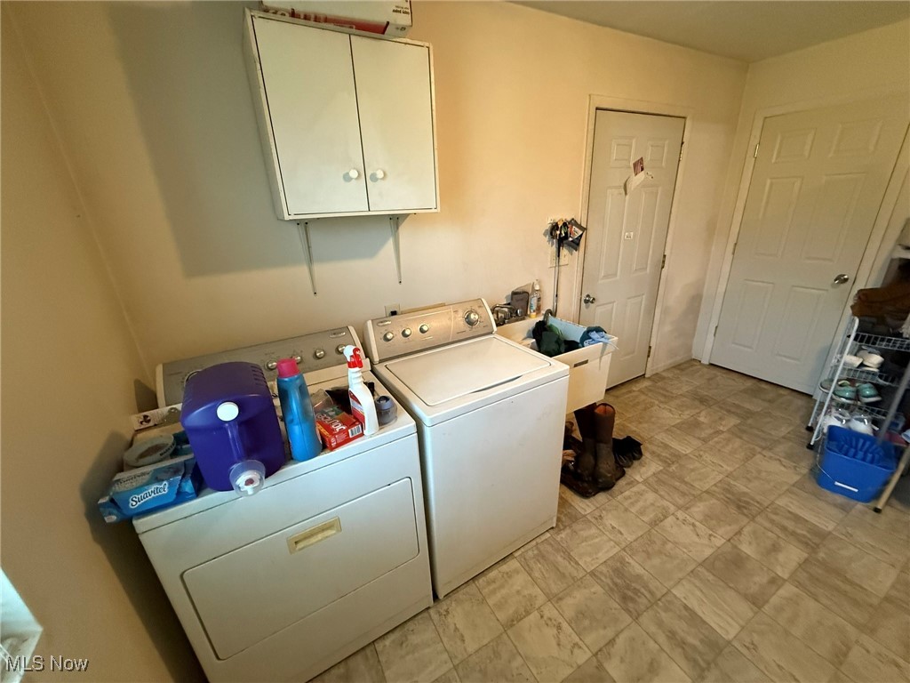 6920 Riverside Road Southeast Gnadenhutten, OH 44629 - Photo 11 of 41 Laundry area featuring washing machine and dryer and cabinet space