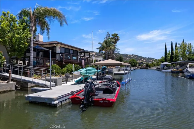 a view of a house with pool and chairs under an umbrella