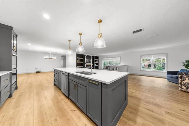 a large kitchen with kitchen island a large island in the center and stainless steel appliances