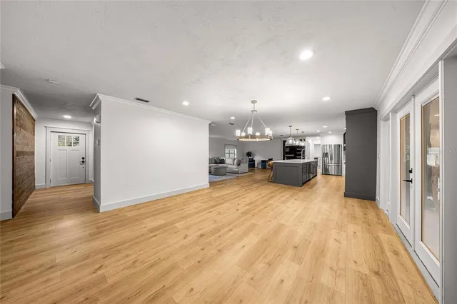 a big room with wooden floor and a kitchen