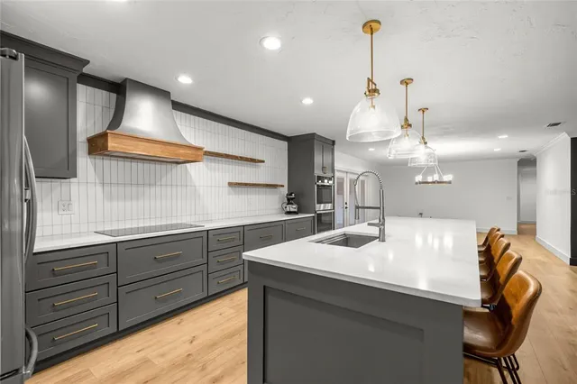 a kitchen with kitchen island stainless steel appliances a sink and a refrigerator