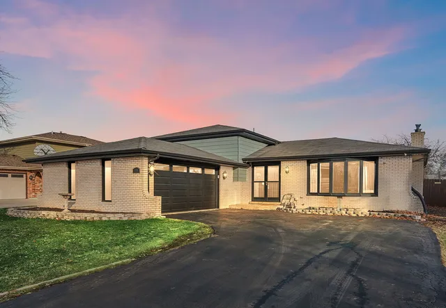 a front view of a house with a garden and yard