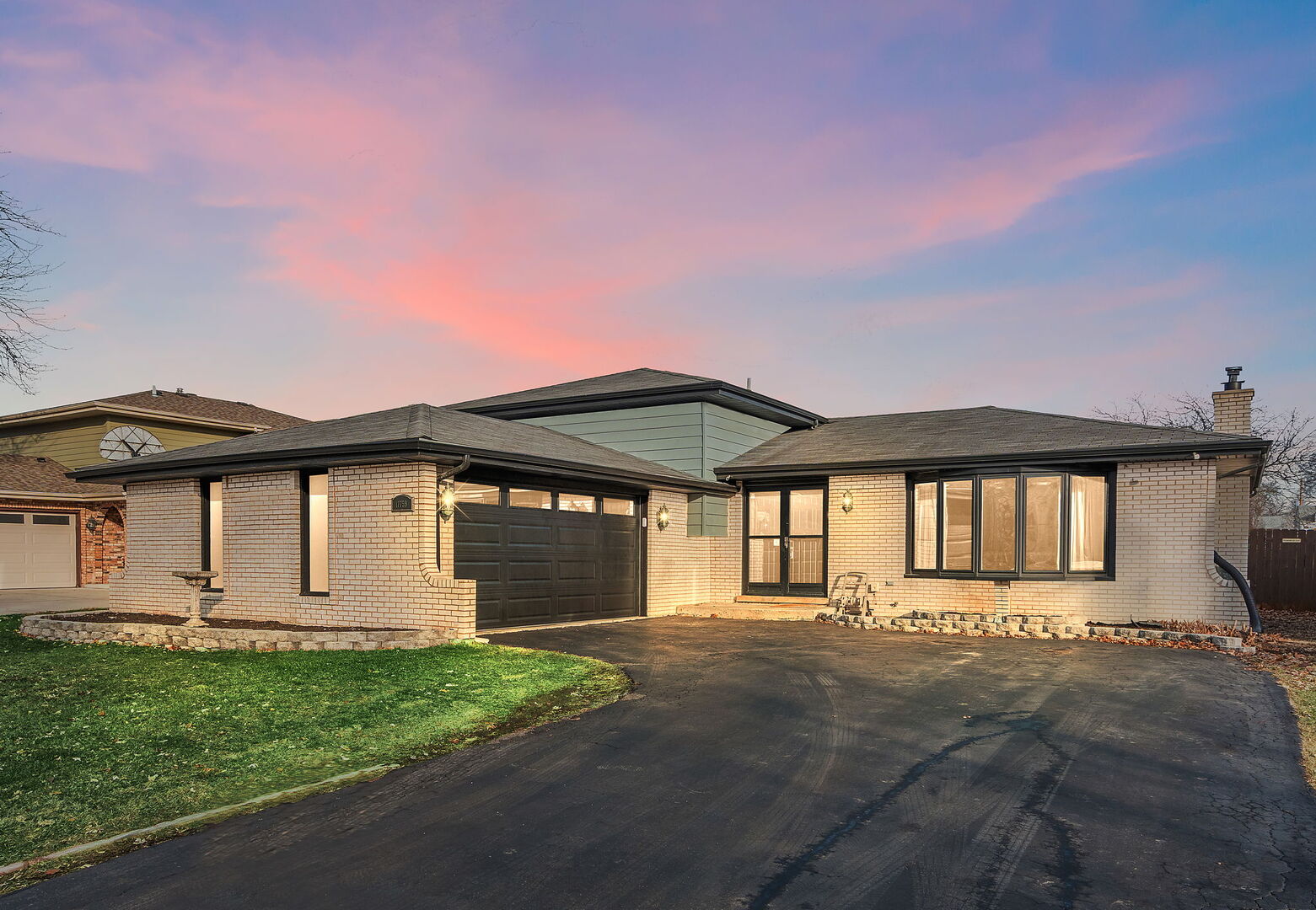 a front view of a house with a garden and yard